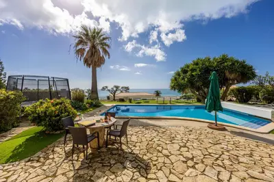 a patio with a table and chairs next to a pool at Seaside Retreat Casa Romana in Luz