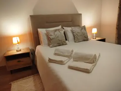 a bedroom with a white bed with two towels on it at Apartamento Quitéria - Funchal in Funchal