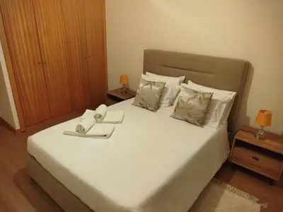 a bedroom with a large bed with white sheets and pillows at Apartamento Quitéria - Funchal in Funchal