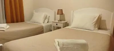 a bedroom with two beds with white sheets and a lamp at Apartamento Quitéria - Funchal in Funchal