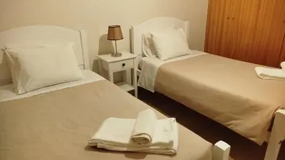 a hotel room with two beds and a towel on a table at Apartamento Quitéria - Funchal in Funchal