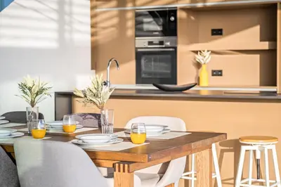 a kitchen and dining room with a wooden table and chairs at Lake House in Calheta