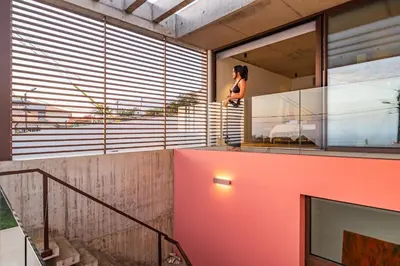 a woman standing on the balcony of a house at Lake House in Calheta