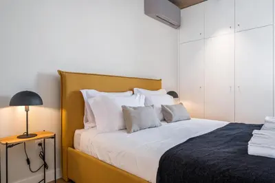 a bedroom with a bed with white sheets and a lamp at Lake House in Calheta