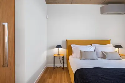 a bedroom with a bed with white sheets and pillows at Lake House in Calheta