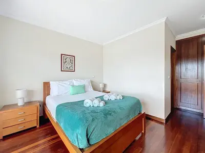 a bedroom with a bed with two stuffed animals on it at Caniço Center Apartment in Caniço
