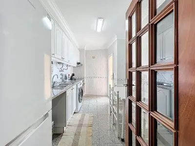 a kitchen with a sink and a washer and dryer at Caniço Center Apartment in Caniço