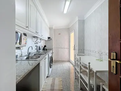 a kitchen with white cabinets and a sink at Caniço Center Apartment in Caniço