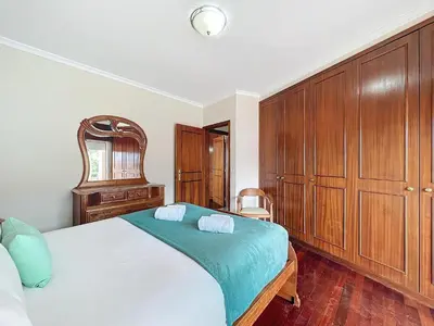 a bedroom with a large bed with wooden cabinets at Caniço Center Apartment in Caniço