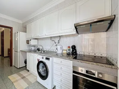 a kitchen with a sink and a washing machine at Caniço Center Apartment in Caniço