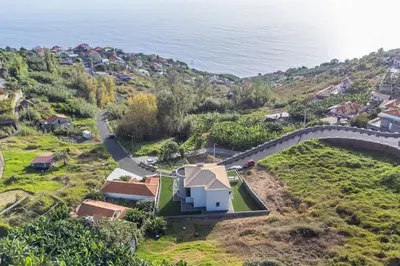 an aerial view of a house on a hill next to the ocean at Yuri Big House in Ribeira Brava