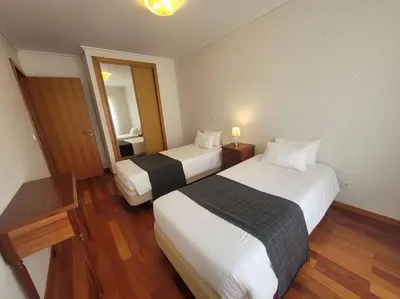 a hotel room with two beds and a mirror at Pilar Balconies in Funchal City in Funchal