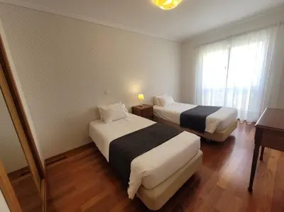 a hotel room with two beds and a window at Pilar Balconies in Funchal City in Funchal