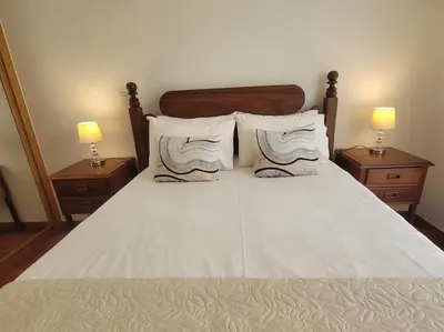 a bedroom with a bed with two nightstands and two lamps at Pilar Balconies in Funchal City in Funchal