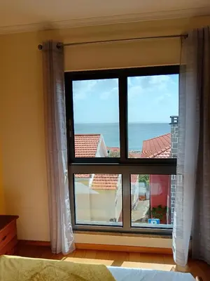 a bedroom with a window with a view of the ocean at Casa da Vila in Santa Cruz