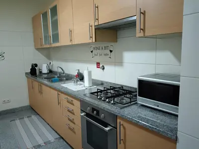a kitchen with a stove and a microwave at Casa da Vila in Santa Cruz