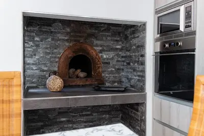 a brick fireplace in a kitchen next to a oven at GuestReady - Leme Beach Breathtaking Views in Gaula