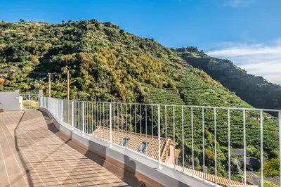 a bridge with a mountain in the background at Stunning view set in nature - Recanto of the sea in Ponta do Sol