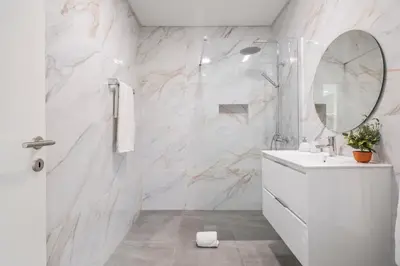 a white bathroom with a sink and a mirror at Stunning view set in nature - Recanto of the sea in Ponta do Sol