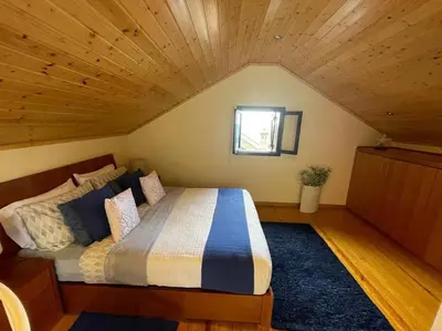 a bedroom with a large bed in a attic at Cozy chalet with ocean view in Seixal
