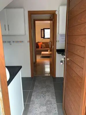 a kitchen with a door leading to a living room at Cozy chalet with ocean view in Seixal