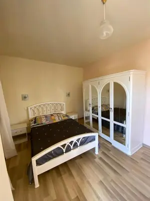 a bedroom with a white bed and a white cabinet at Maria Holiday House in São Jorge