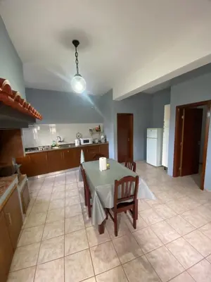 a kitchen and dining room with a table and chairs at Maria Holiday House in São Jorge