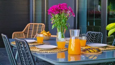 a table with a vase of flowers and orange juice at Roots Loft by LovelyStay in Funchal