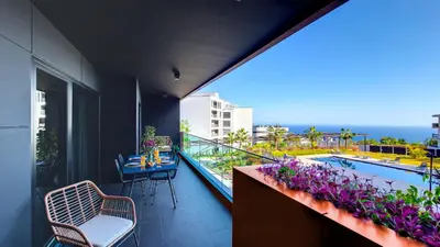 a balcony with a table and chairs and a swimming pool at Roots Loft by LovelyStay in Funchal