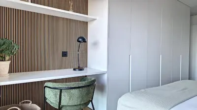 a bedroom with a green chair and a wall with stripes at Roots Loft by LovelyStay in Funchal