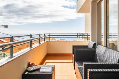 a balcony with two chairs and a table at Freitas House by Homie in Ponta do Sol