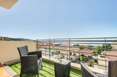 a balcony with chairs and a view of a city at Freitas House by Homie in Ponta do Sol