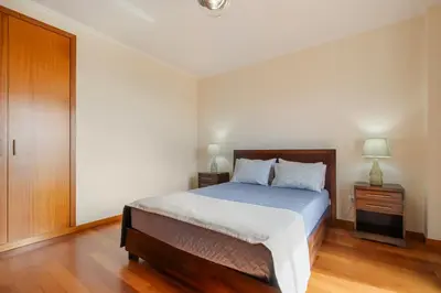 a bedroom with a bed and a wooden floor at Freitas House by Homie in Ponta do Sol