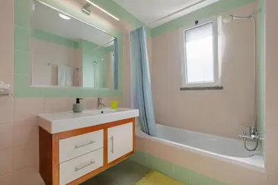 a bathroom with a sink and a tub and a mirror at Freitas House by Homie in Ponta do Sol