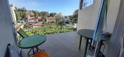 a balcony with two tables and chairs on a balcony at Sunrise View in Funchal