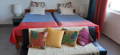 two beds with colorful pillows in a room at Sunrise View in Funchal