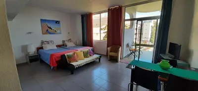 a bedroom with a bed and a tv and a window at Sunrise View in Funchal