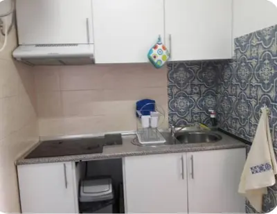 a small kitchen with white cabinets and a sink at Sunrise View in Funchal