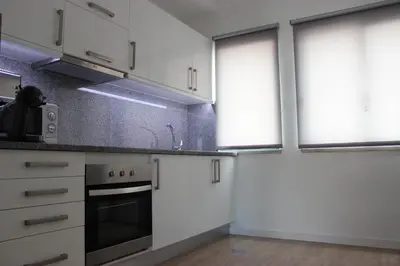 a kitchen with white cabinets and a stove at Berna Apartment in Funchal