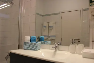 a bathroom with a sink with a mirror and towels at Berna Apartment in Funchal