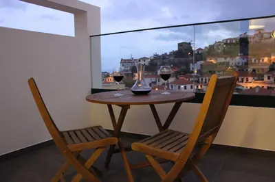 a table with two chairs and two glasses of wine at Berna Apartment in Funchal