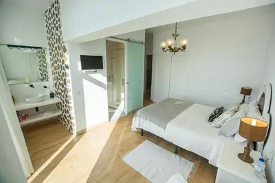 a bedroom with a bed and a mirror at Vila Fortaleza in Aljezur