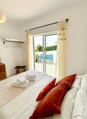 a bedroom with a large bed and a sliding glass door at Vila Fortaleza in Aljezur