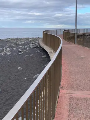 a wooden fence next to a beach with the ocean at Praia Formosa Ocean View - Funchal in Funchal