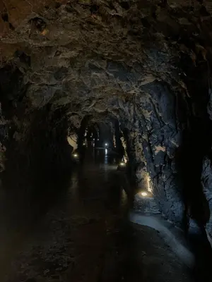 a dark tunnel with lights in a cave at Praia Formosa Ocean View - Funchal in Funchal