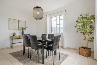 a dining room with a black table and black chairs at Sunny House by Homie in Canhas