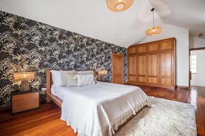 a bedroom with a bed with a black and white wallpaper at Sunny House by Homie in Canhas