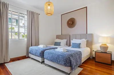 a bedroom with two beds and a window at Sunny House by Homie in Canhas
