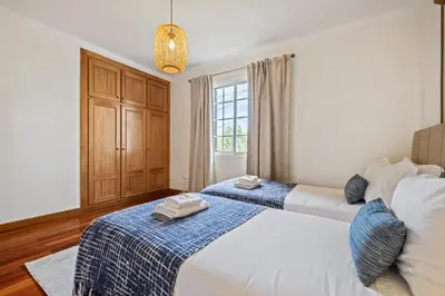 a bedroom with two beds and a window at Sunny House by Homie in Canhas