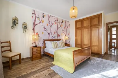 a bedroom with a bed and a chair at Sunny House by Homie in Canhas